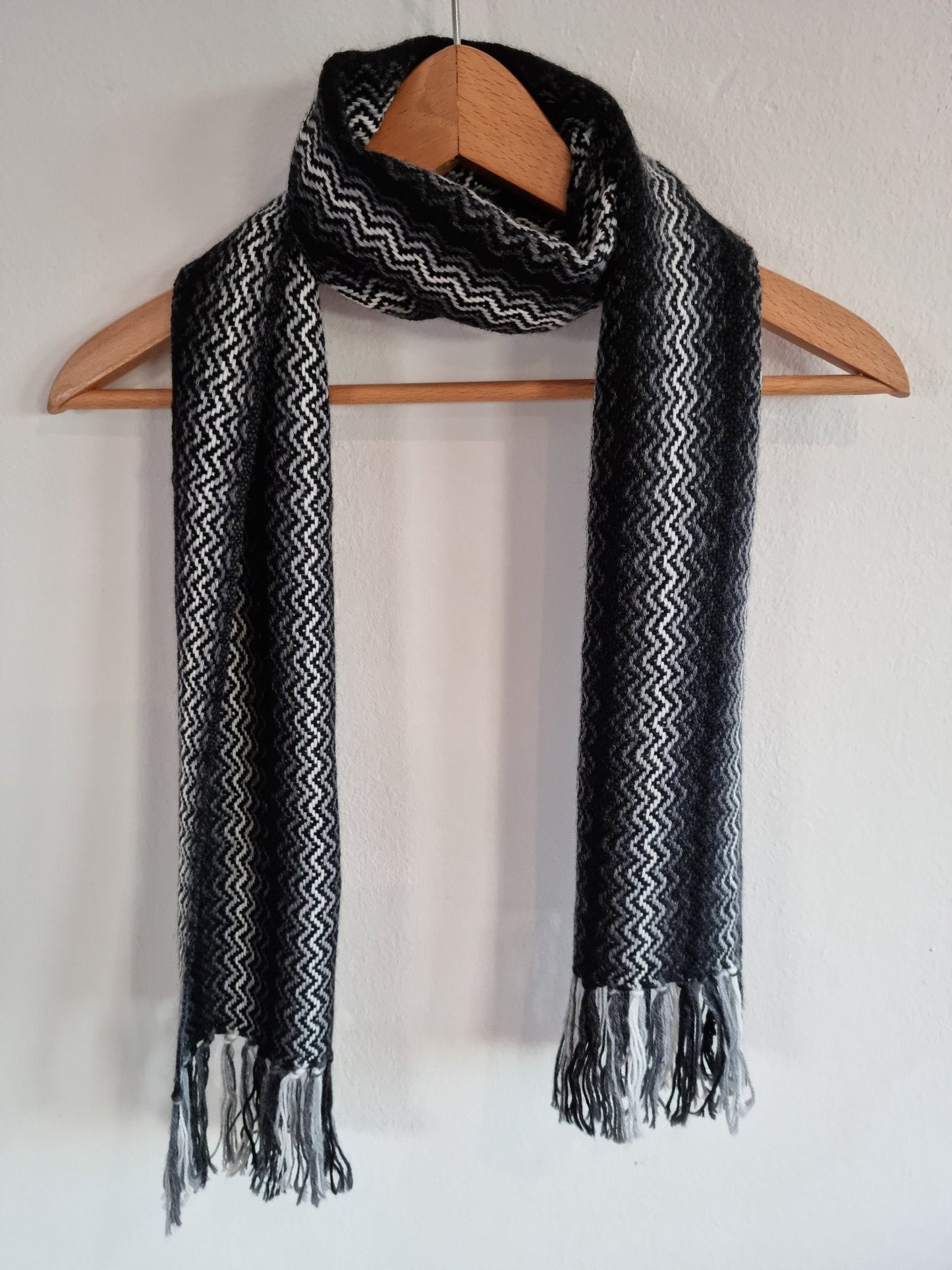 Black and gray handmade alpaca shawl with zigzag pattern and fringed ends.