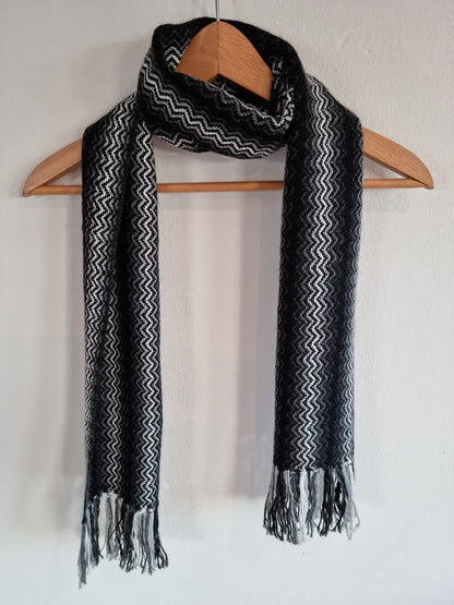 Black and gray handmade alpaca shawl with zigzag pattern and fringed ends.
