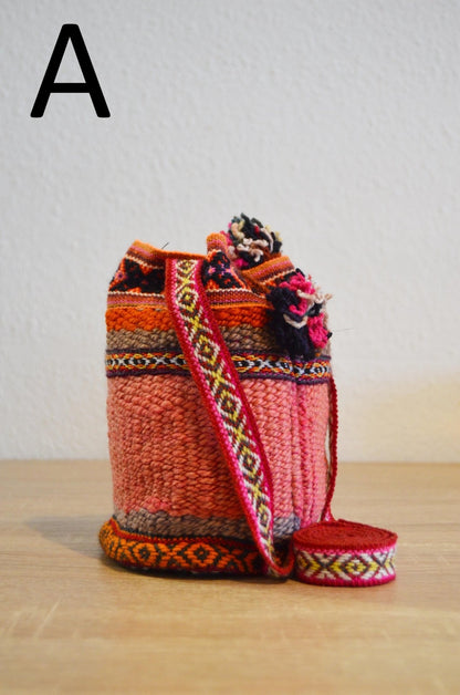 Handmade small alpaca shoulder bag with vibrant red and orange traditional Andean patterns.