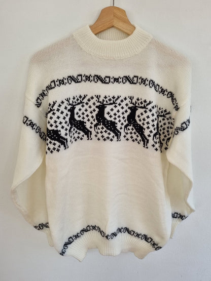 Handmade white alpaca sweater with black llama pattern and high neckline.