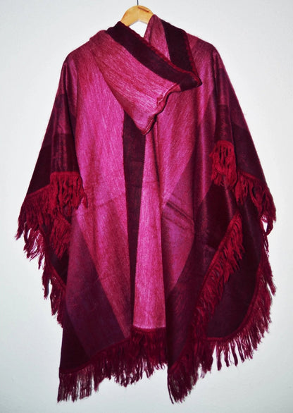 Handmade alpaca wool poncho shawl in rich burgundy and pink hues with hood and fringe detailing.