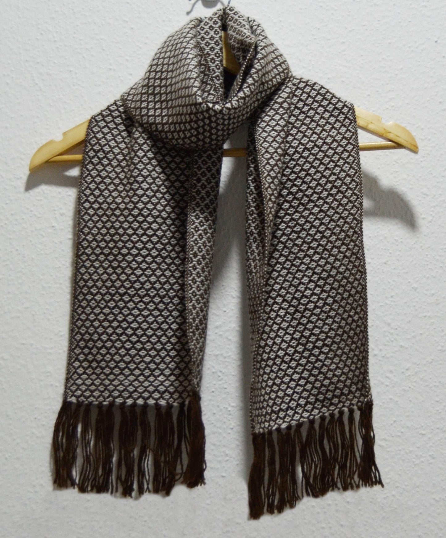 Handmade Peruvian alpaca shawl in gray with intricate diamond pattern and fringed edges.