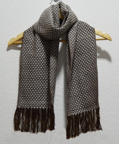 Handmade Peruvian alpaca shawl in gray with intricate diamond pattern and fringed edges.