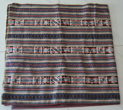 Handmade alpaca textile blanket with colorful geometric Andean patterns on cream background.