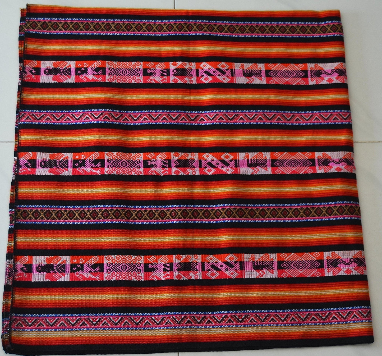 Handmade alpaca mantel Mestana with vibrant orange, red, and black traditional Andean patterns.