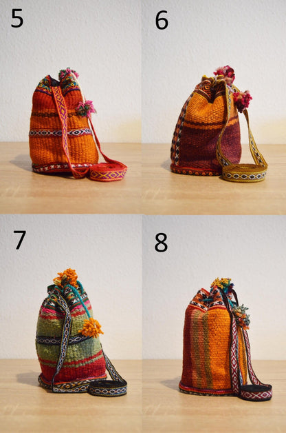 Handmade alpaca mini shoulder bag with orange, yellow, and brown Andean patterns and pom-pom closures.