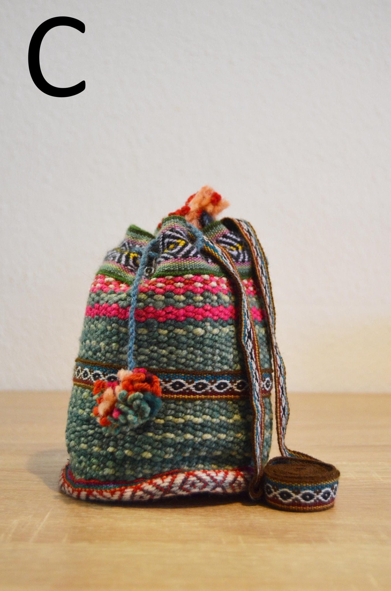 Handmade alpaca mini shoulder bag with colorful ethnic patterns and braided strap.