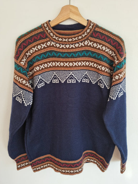 Handmade alpaca wool sweater with geometric patterns in brown, teal, and white on navy background.