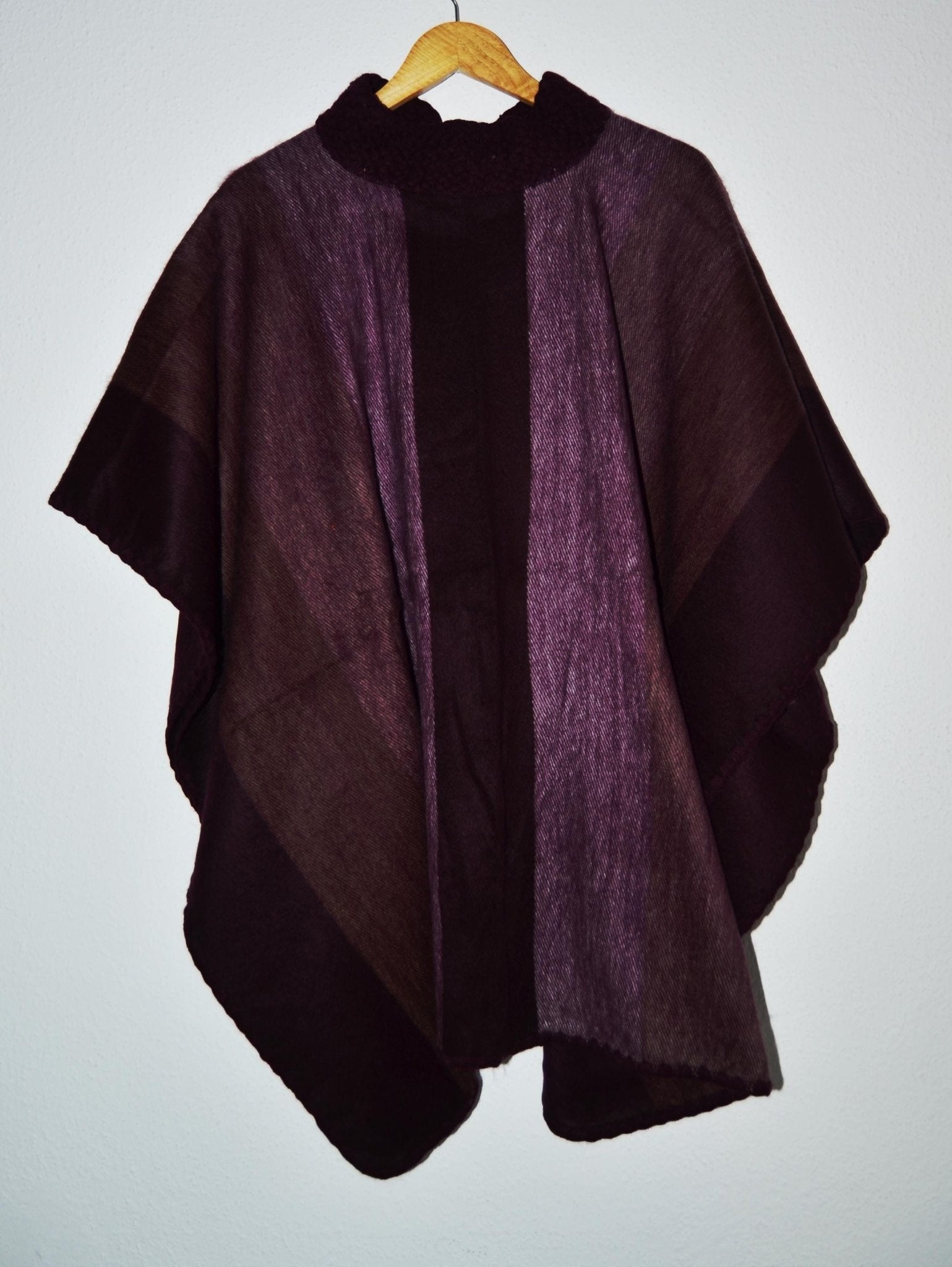 Handmade alpaca wool poncho shawl in dark purple and brown with soft, textured fabric and cozy drape.