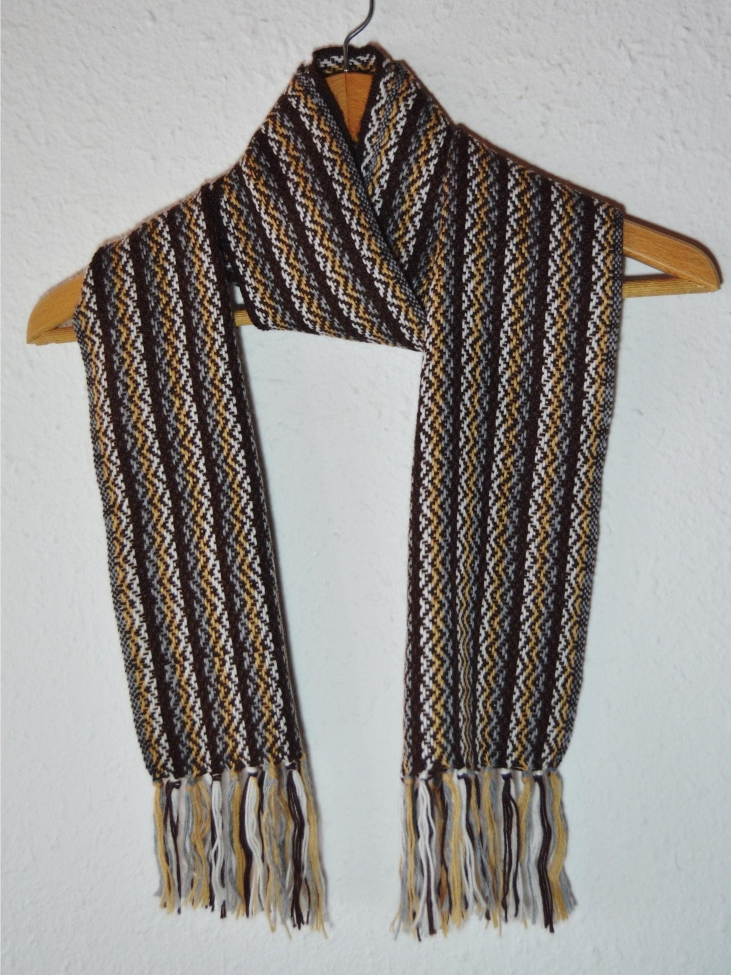 Handmade Peruvian alpaca wool shawl with brown, beige, and black geometric patterns and fringe ends.