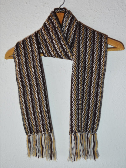 Handmade Peruvian alpaca wool shawl with brown, beige, and black geometric patterns and fringe ends.