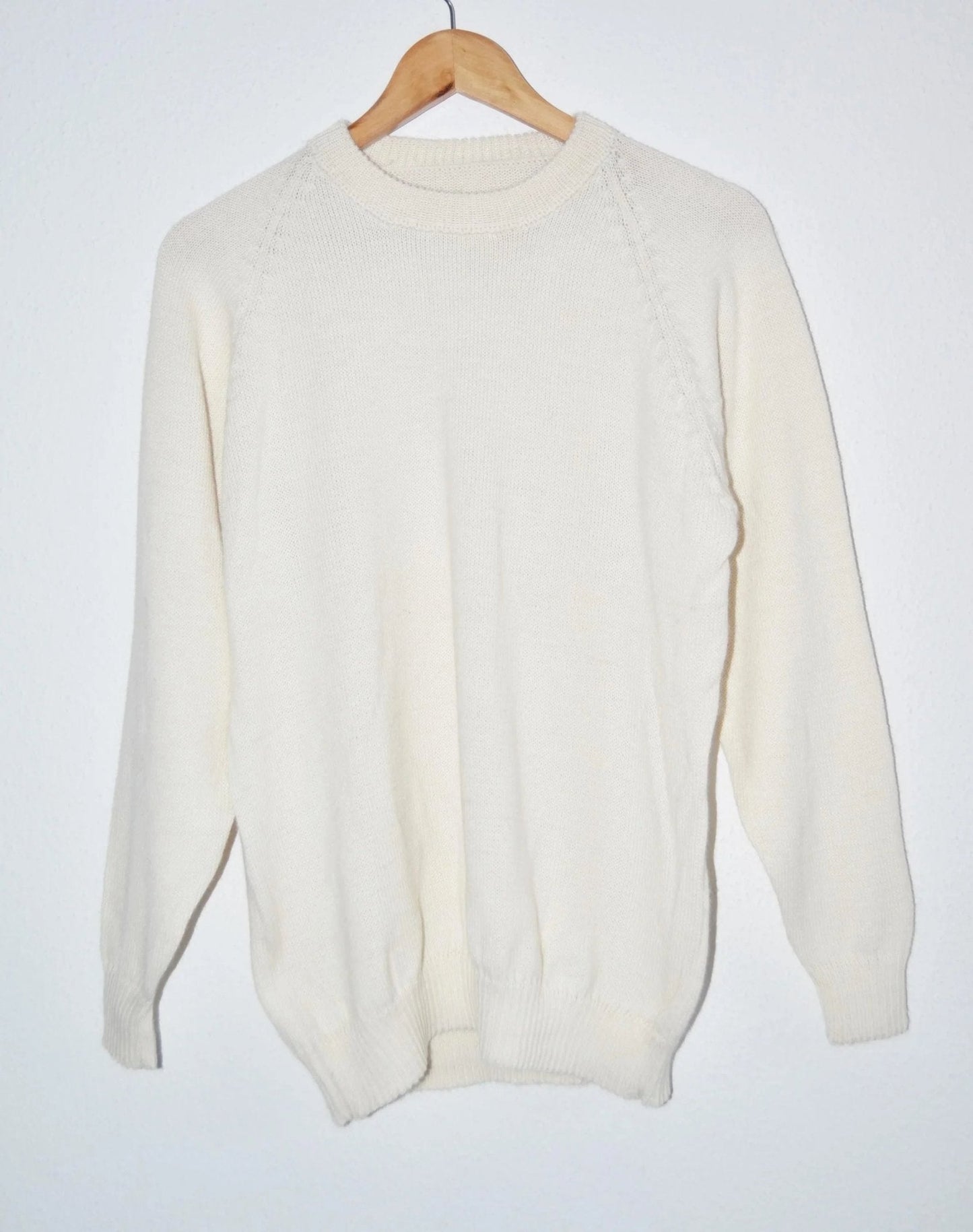 Cream handmade alpaca sweater with subtle knit detailing on shoulder and ribbed cuffs.