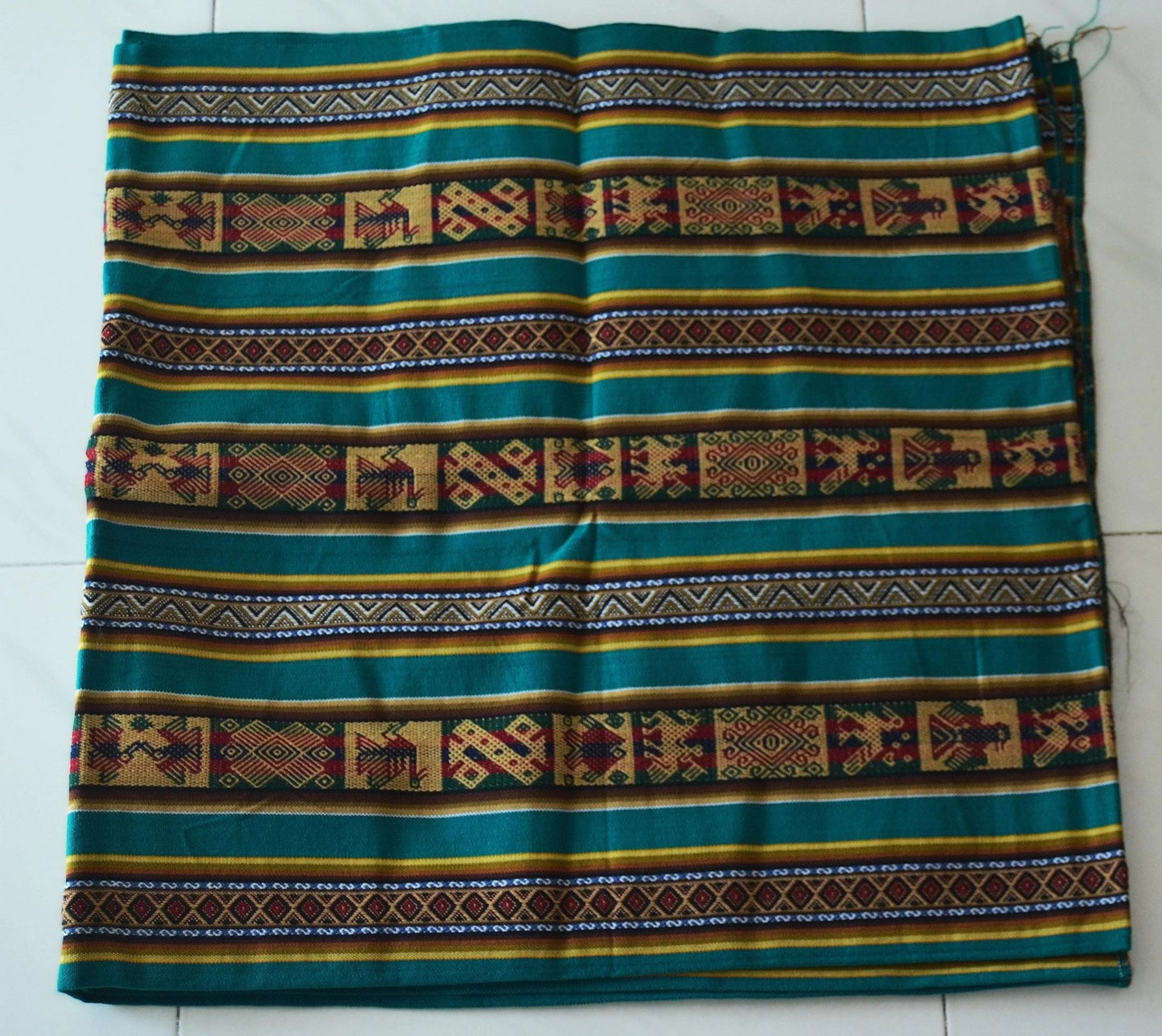 Handmade alpaca fabric with green, brown, and yellow traditional Andean patterns and geometric designs.