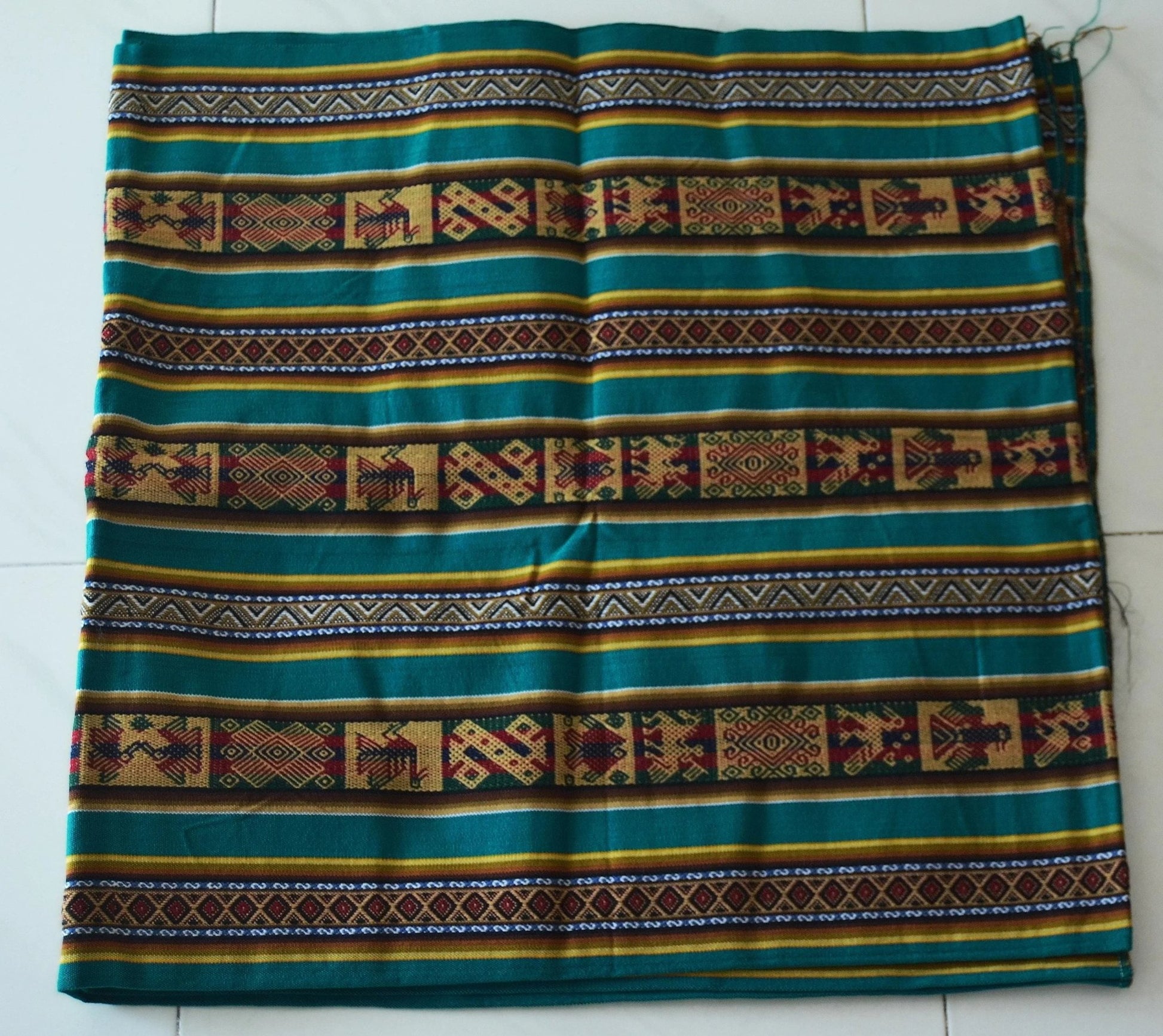 Handmade alpaca fabric with green, brown, and yellow traditional Andean patterns and geometric designs.