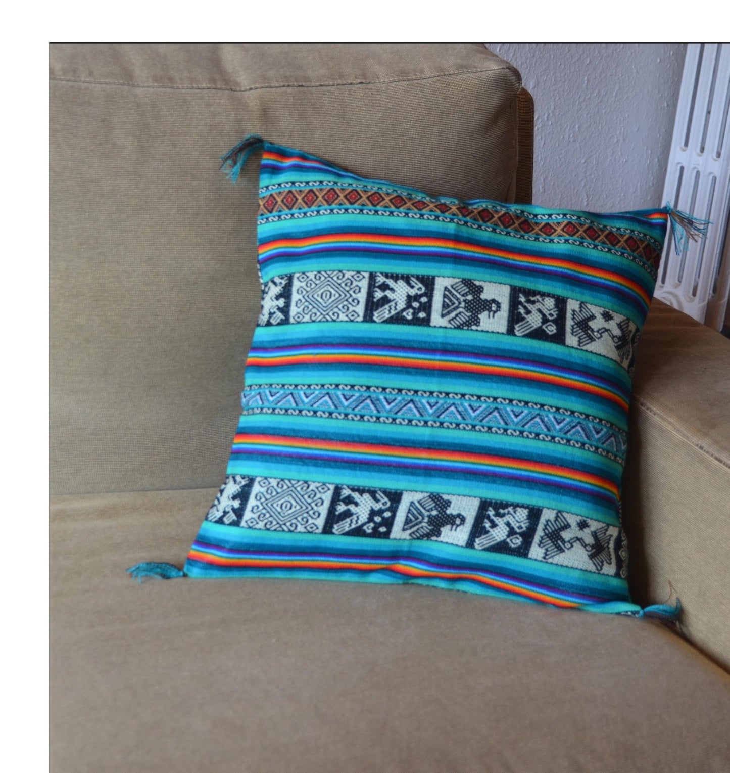 Handmade Peruvian alpaca pillow with colorful woven geometric and animal patterns in turquoise and blue tones.