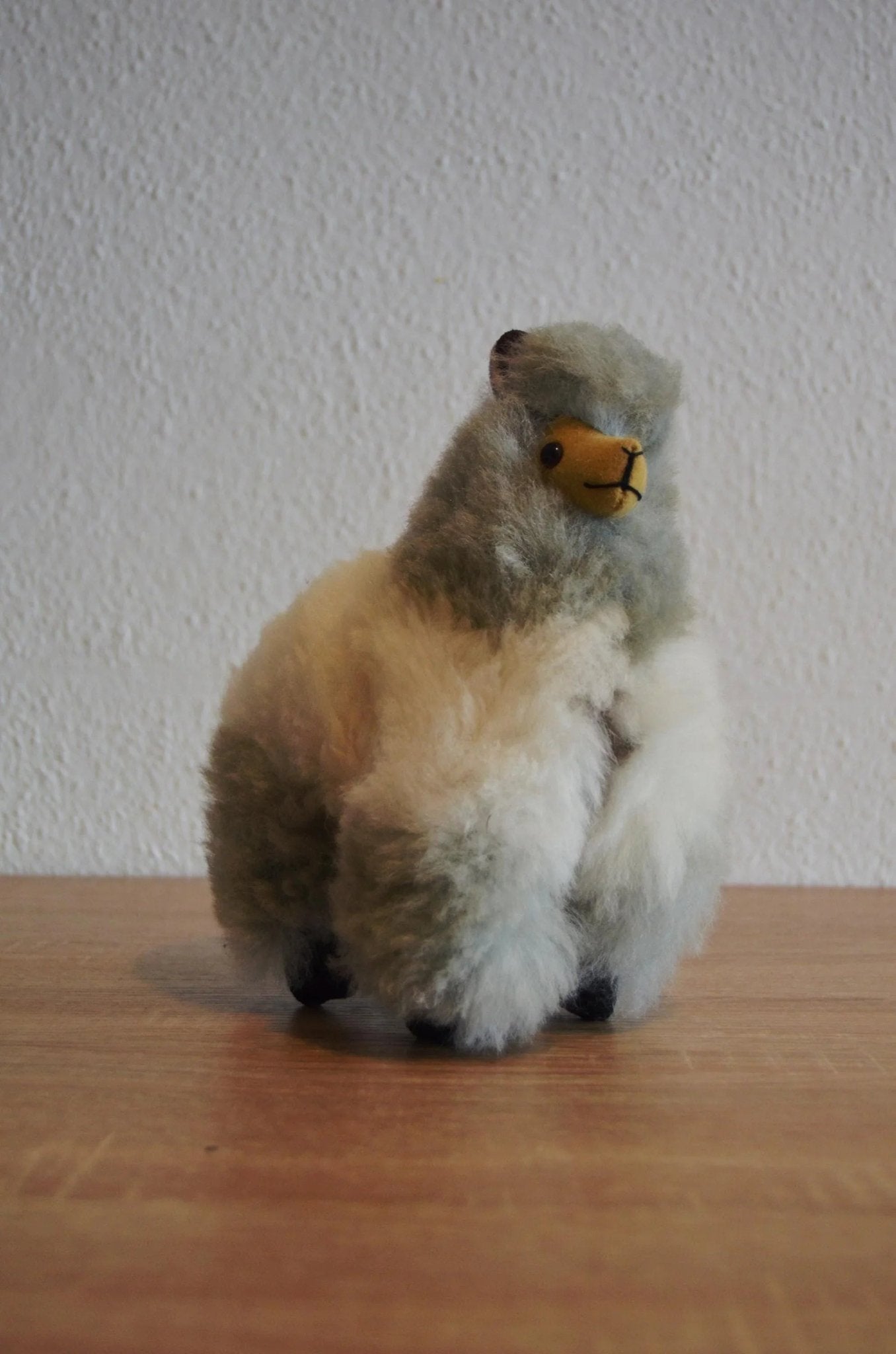 Handmade soft alpaca plush in white and gray with detailed face and fluffy texture.