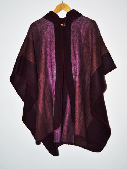 Handmade alpaca wool poncho shawl in deep purple with vertical stripe pattern and wooden toggle closures.