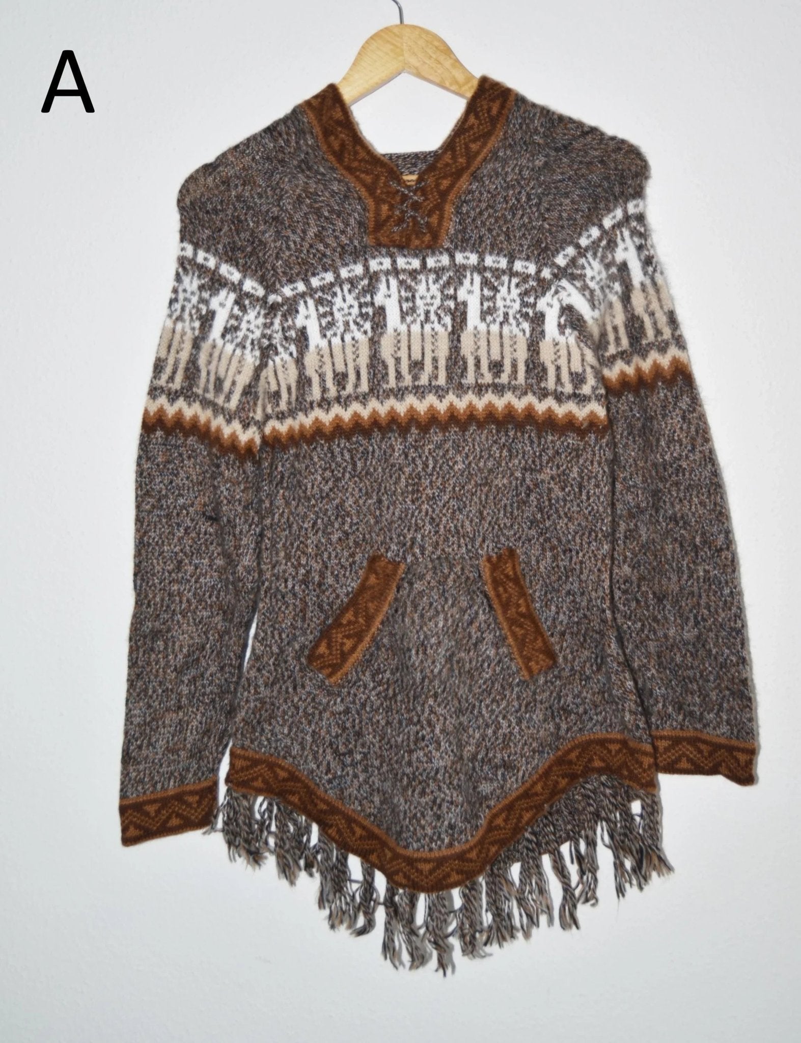 Handmade alpaca sweater with brown geometric patterns, front pockets, and fringe hem.