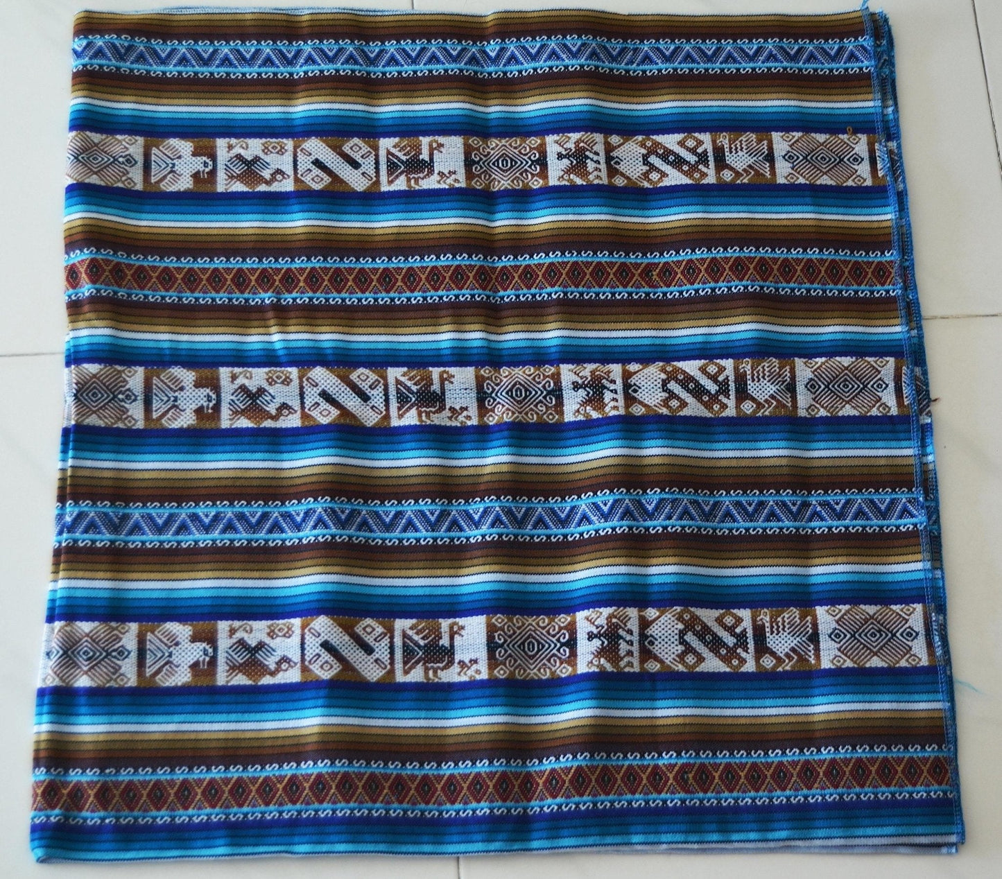 Handmade alpaca fabric with blue, brown, and white geometric Andean patterns textile.