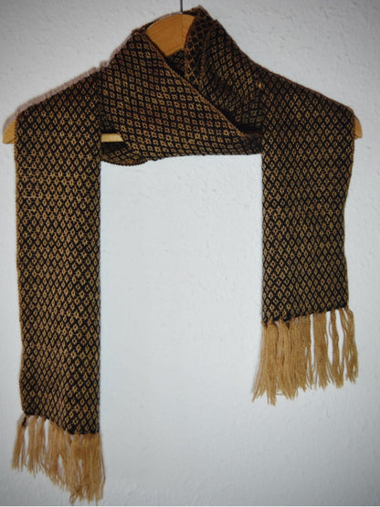 Handmade black and brown alpaca wool shawl with geometric pattern and fringed ends.