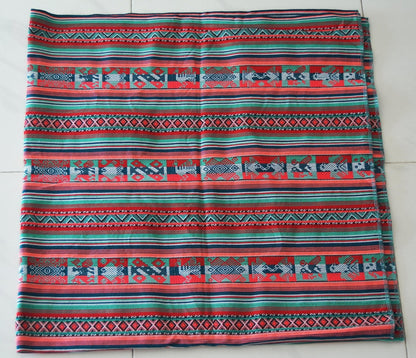 Handmade alpaca blanket with colorful geometric and animal patterns in red, blue, and green tones.