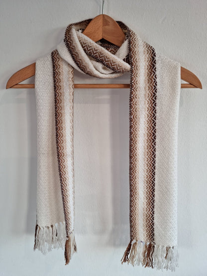 Handmade alpaca shawl in creamy white with vertical brown stripes and fringed edges.
