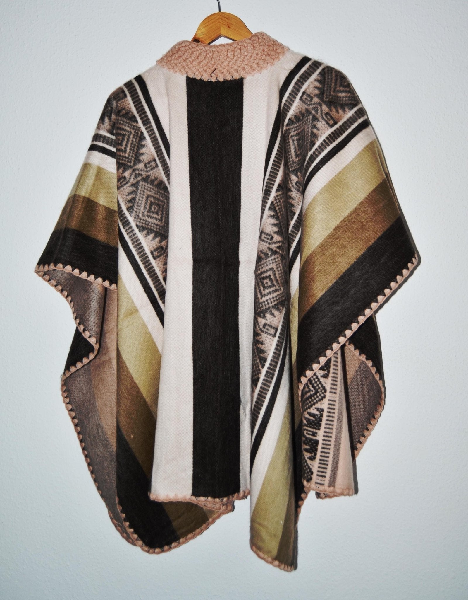 Handmade alpaca wool poncho shawl in earthy tones with traditional geometric patterns and soft texture.