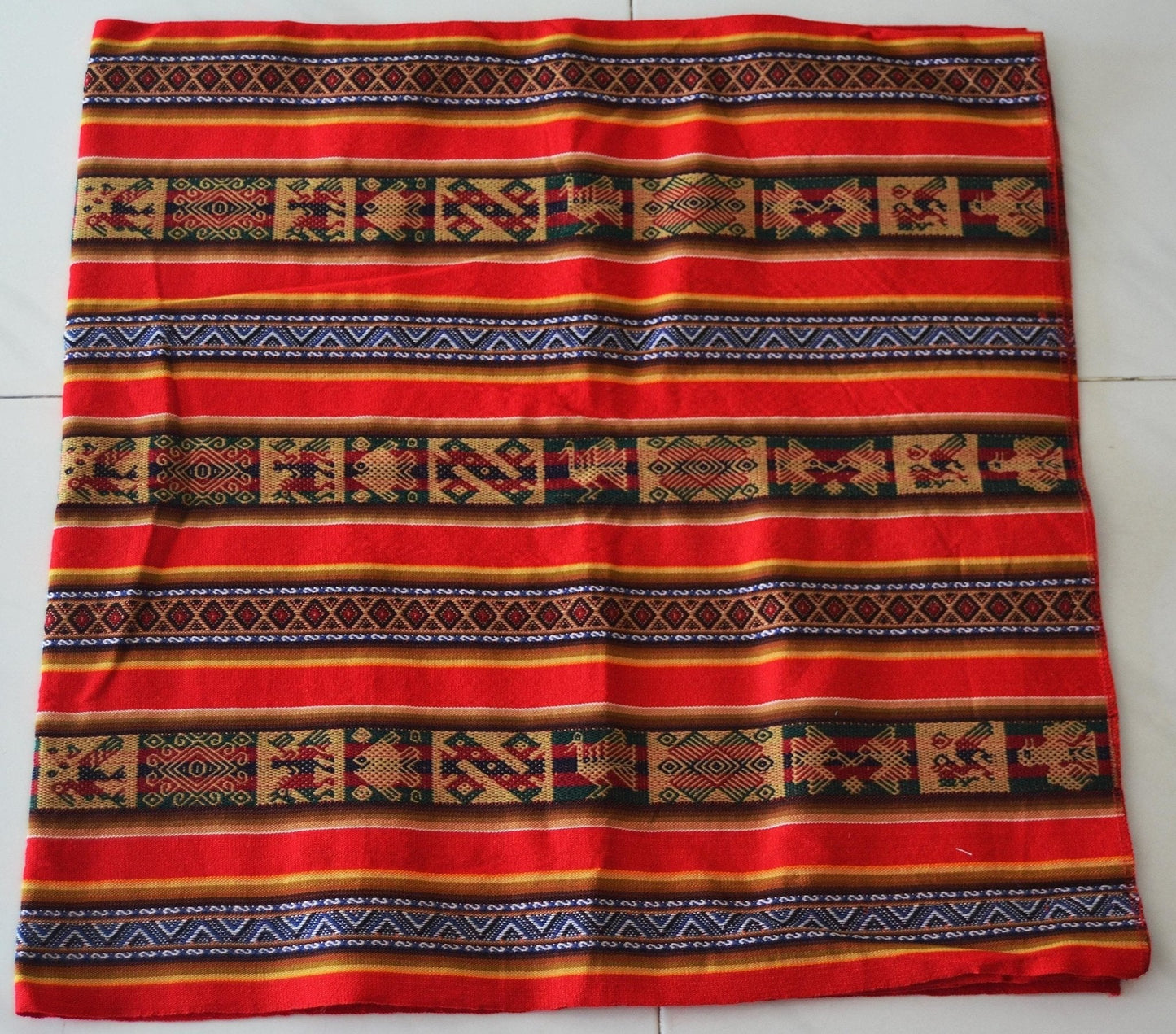 Handmade alpaca fabric with red, orange, and blue geometric patterns in Andean style.