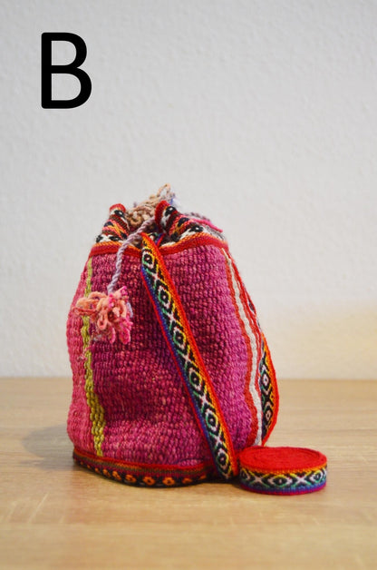 Handmade alpaca mini shoulder bag with vibrant pink woven fabric and colorful geometric strap.